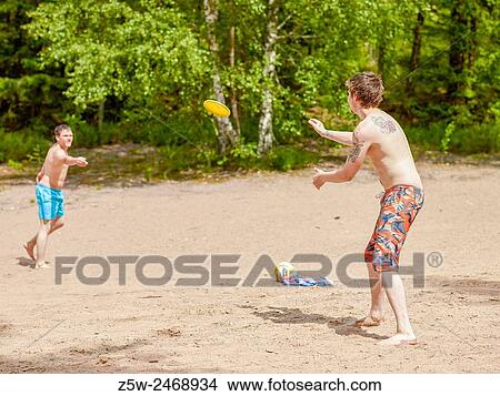 Picture - The friends chilling out on the beach, summer day. Shot in southern Finland.. Fotosearch