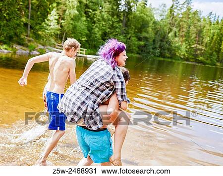 Stock Image - The group of the friends chilling out on the beach, summer day. Shot in southern Finland.. Fotosearch
