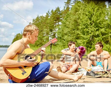 The group of the friends chilling out on the beach, summer day. Shot in southern Finland. View Large Photo Image Stock Photo - The group of the friends chilling out on the beach, summer day. Shot in southern Finland.. Fotosearch