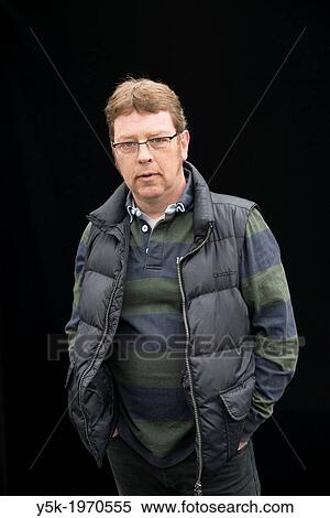 Tilburg, Netherlands. Self-portrait of a middle aged man with glasses against a black background. Portrait session on the weekly market. View Large Photo Image Stock Photography - Tilburg, Netherlands. Self-portrait of a middle aged man with glasses against a black background. Portrait session on the weekly market.. Fotosearch