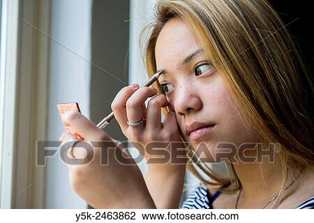 Tilburg, Netherlands. Studio portrait of a young Chinese girl doing her make up. View Large Photo Image Stock Image - Tilburg, Netherlands. Studio portrait of a young Chinese girl doing her make up.. Fotosearch