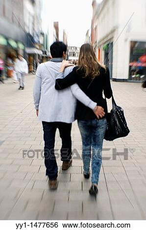 Tilburg, Netherlands. Young couple walking down high street arm in arm. View Large Photo Image Stock Photograph - Tilburg, Netherlands. Young couple walking down high street arm in arm.. Fotosearch