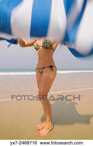 Stock Photograph - Woman with towel at the beach.. Fotosearch