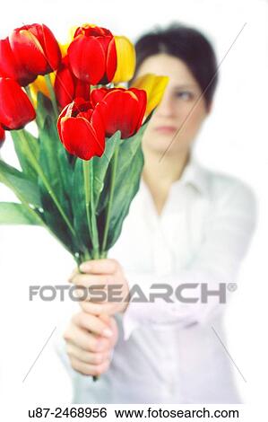 Stock Photograph - Young woman holding an artificial flower... Fotosearch
