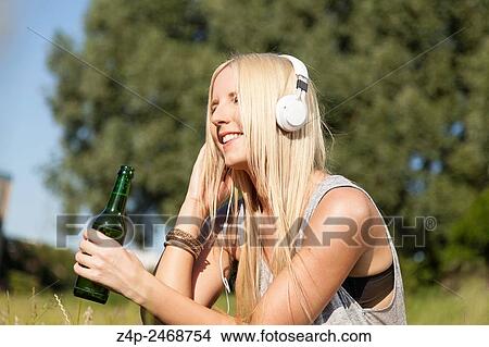 Young woman listening to music View Large Photo Image Picture - Young woman listening to music. Fotosearch