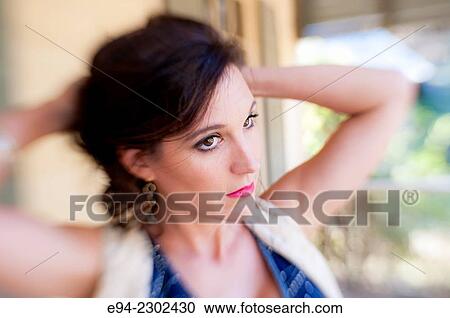 36 year old brunette woman outdoors standing on a porch of an old house looking away from the camera, hands in back of her head. View Large Photo Image Stock Image - 36 year old brunette woman outdoors standing on a porch of an old house looking away from the camera, hands in back of her head.. Fotosearch