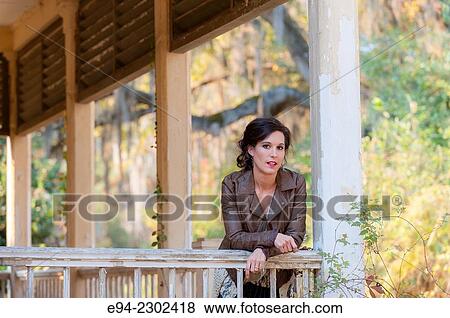 36 year old brunette woman outdoors standing on a porch of an old house looking directly at the camera. View Large Photo Image Stock Photo - 36 year old brunette woman outdoors standing on a porch of an old house looking directly at the camera.. Fotosearch
