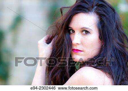 36 year old brunette woman outdoors looking over her shoulder directly at the camera. View Large Photo Image Stock Photograph - 36 year old brunette woman outdoors looking over her shoulder directly at the camera.. Fotosearch