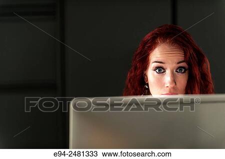 37 year old redheaded woman looking at the camera over a computer screen. View Large Photo Image Stock Image - 37 year old redheaded woman looking at the camera over a computer screen.. Fotosearch
