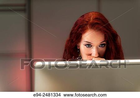 37 year old redheaded woman which had over her mouth and looking down at a computer screen. View Large Photo Image Picture - 37 year old redheaded woman which had over her mouth and looking down at a computer screen.. Fotosearch