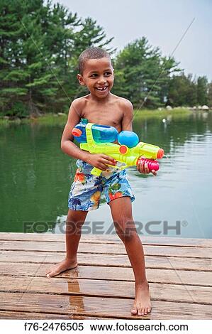 6 year old african american boy playing with fanciful water ´gun´ while standing on wooden dock in Gloucester, MA, mr_G110806_1. View Large Photo Image Stock Photography - 6 year old african american boy playing with fanciful water ´gun´ while standing on wooden dock in Gloucester, MA, mr_G110806_1.. Fotosearch