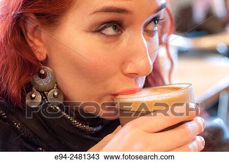 A 37 year old redheaded woman sipping coffee in a cafe, looking away from the camera. View Large Photo Image Stock Image - A 37 year old redheaded woman sipping coffee in a cafe, looking away from the camera.. Fotosearch
