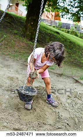 A four years old caucasian girl playing with sand in a playground. View Large Photo Image Stock Image - A four years old caucasian girl playing with sand in a playground.. Fotosearch