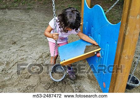 A four years old caucasian girl playing with sand in a public playground. View Large Photo Image Stock Image - A four years old caucasian girl playing with sand in a public playground.. Fotosearch