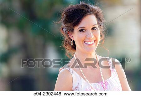 A portrait of a smiling 36 year old brunette woman looking directly at the camera, outdoors. View Large Photo Image Stock Photo - A portrait of a smiling 36 year old brunette woman looking directly at the camera, outdoors.. Fotosearch