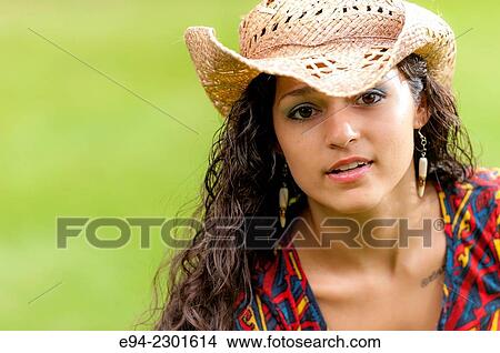 Picture - A smiling 19 year old brunette woman wearing a straw hat looking at the camera.. Fotosearch