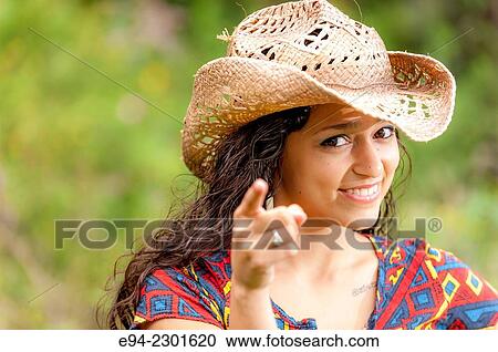 A smiling 19 year old brunette woman wearing a straw hat looking and pointing her finger at the camera. View Large Photo Image Stock Image - A smiling 19 year old brunette woman wearing a straw hat looking and pointing her finger at the camera.. Fotosearch