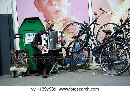 A streetmusician with accordion plays his tunes in the streets of Utrecht. View Large Photo Image Stock Photography - A streetmusician with accordion plays his tunes in the streets of Utrecht.. Fotosearch