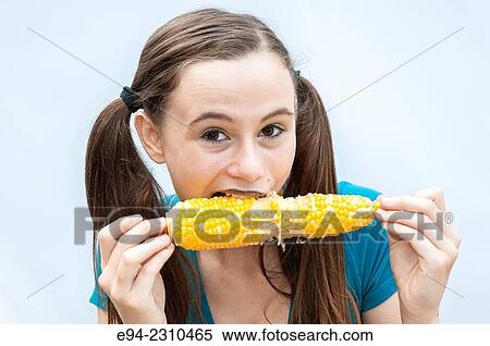 An 18 year old woman eating corn on the cob and looking at the camera. View Large Photo Image Stock Photography - An 18 year old woman eating corn on the cob and looking at the camera.. Fotosearch