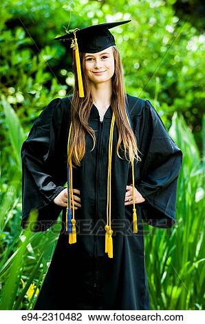 An 18 year old woman wearing a cap and gown for high school graduation smiling at the camera in garden setting. View Large Photo Image Stock Image - An 18 year old woman wearing a cap and gown for high school graduation smiling at the camera in garden setting.. Fotosearch