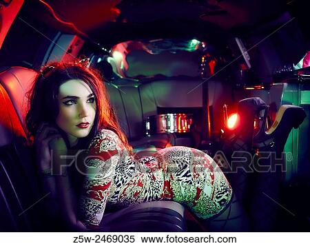 Stock Photography - Attractive brunette girl posing inside the limousine.. Fotosearch