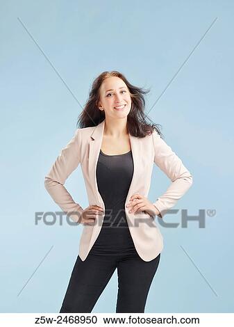 Stock Image - Attractive young woman posing in studio, light blue background - healthy lifestyle theme.. Fotosearch