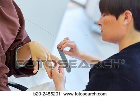 Beautician filing nails a woman. Manicure. Hairdressing salon and Beauty Clinic. View Large Photo Image Stock Image - Beautician filing nails a woman. Manicure. Hairdressing salon and Beauty Clinic.. Fotosearch