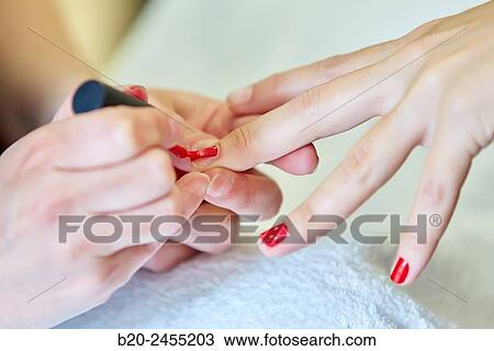 Stock Image - Beautician painting nails a woman. Manicure. Hairdressing salon and Beauty Clinic.. Fotosearch