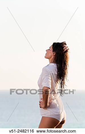 Beautiful brunette woman stretching by the sea View Large Photo Image Stock Photograph - Beautiful brunette woman stretching by the sea. Fotosearch