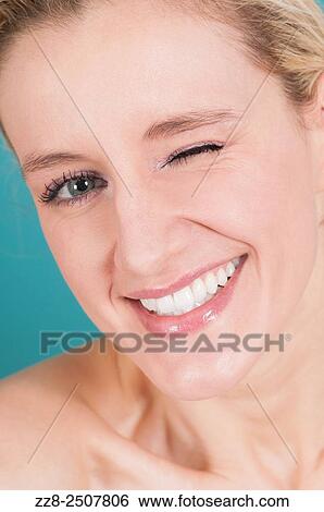 Stock Photograph - Beautiful young Caucasian woman winking.. Fotosearch