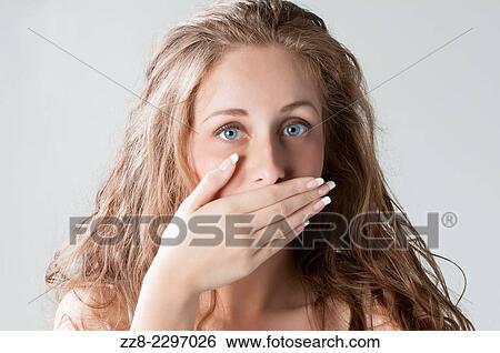 Stock Photograph - Beautiful young woman hand covering mouth.. Fotosearch
