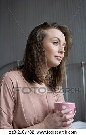Beautiful young woman having coffee in bed looking away. View Large Photo Image Stock Image - Beautiful young woman having coffee in bed looking away.. Fotosearch