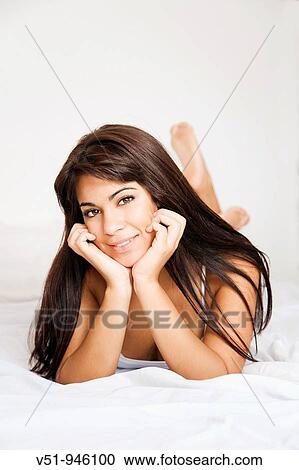 Brunette woman lying down in bed View Large Photo Image Stock Image - Brunette woman lying down in bed. Fotosearch