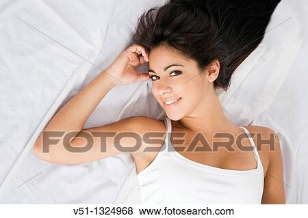 Brunette woman lying down in bed View Large Photo Image Stock Photo - Brunette woman lying down in bed. Fotosearch