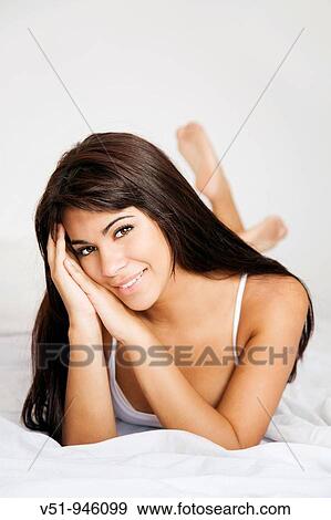 Brunette woman lying down in bed View Large Photo Image Stock Photo - Brunette woman lying down in bed. Fotosearch