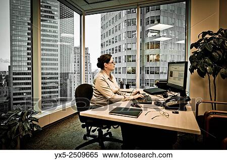 Business woman executive in a corner office sitting at the desk. View Large Photo Image Stock Photography - Business woman executive in a corner office sitting at the desk.. Fotosearch
