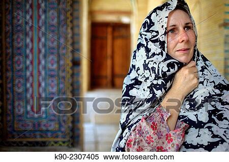 Stock Photography - Caucasian female tourist passing by and looking around at Nazir-al Molk Mosque (Masjed-e Nazir-al-Molk), Shiraz, Iran, Central Asia.. Fotosearch