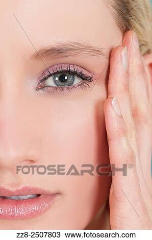 Stock Image - Close up of a beautiful woman hand touching face. Fotosearch