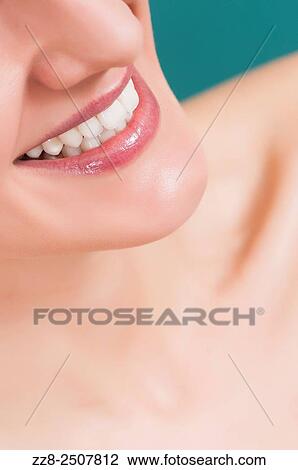 Stock Image - Closeup of a beautiful young woman smiling with healthy white teeth.. Fotosearch