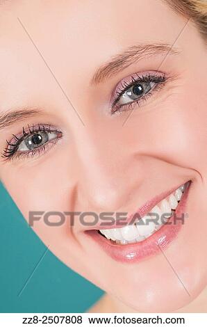 Stock Photo - Closeup of a beautiful young woman smiling with healthy white teeth.. Fotosearch