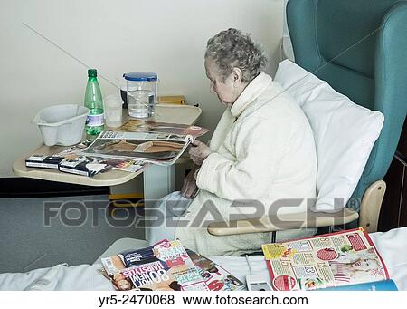 Stock Photo - Elderly lady in her nineties on NHS hospital ward with jug of water on bedside table. England, United Kingdom.. Fotosearch