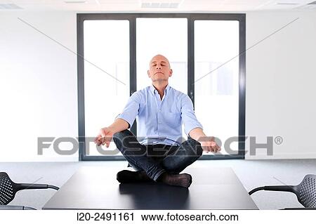 Executive doing Yoga. Empty office. Meeting room. View Large Photo Image Stock Image - Executive doing Yoga. Empty office. Meeting room.. Fotosearch