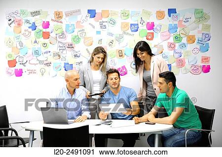 Stock Image - Executives at meeting table. Office. Coworking.. Fotosearch