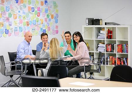 Stock Photo - Executives at meeting table. Office. Coworking.. Fotosearch