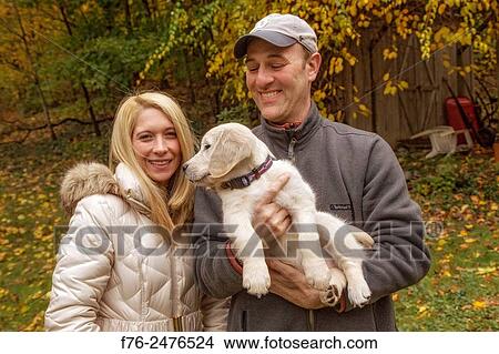 famiily portrait of a 10 week old golden retriever puppy with his family, mr# 6531. View Large Photo Image Picture - famiily portrait of a 10 week old golden retriever puppy with his family, mr# 6531.. Fotosearch