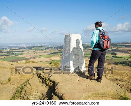 Stock Image - Female hiker on summit of Roseberry Topping in North York Moors National Park, North Yorkshire, England, United Kingdom.. Fotosearch