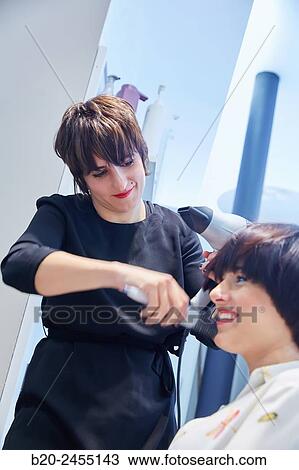 Hairdresser combing the hair of a woman. Hairdressing salon and Beauty Clinic. View Large Photo Image Stock Image - Hairdresser combing the hair of a woman. Hairdressing salon and Beauty Clinic.. Fotosearch