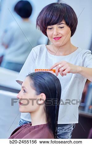 Hairdresser combing the hair of a woman. Hairdressing salon and Beauty Clinic. View Large Photo Image Stock Photograph - Hairdresser combing the hair of a woman. Hairdressing salon and Beauty Clinic.. Fotosearch