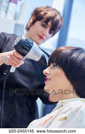 Hairdresser combing the hair of a woman. Hairdressing salon and Beauty Clinic. View Large Photo Image Stock Photography - Hairdresser combing the hair of a woman. Hairdressing salon and Beauty Clinic.. Fotosearch