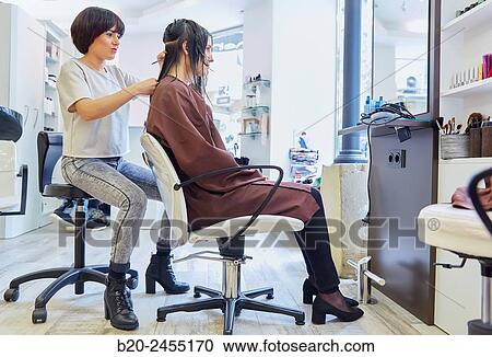 Stock Image - Hairdresser cutting the hair of a woman. Hairdressing salon and Beauty Clinic.. Fotosearch